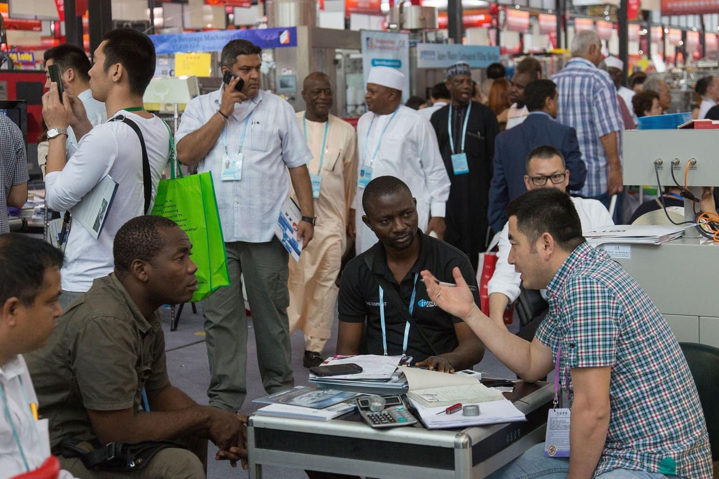 International business visitors and Chinese exhibitors talking at a trade fair